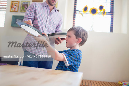 Son setting the table with father Son setting the table with father