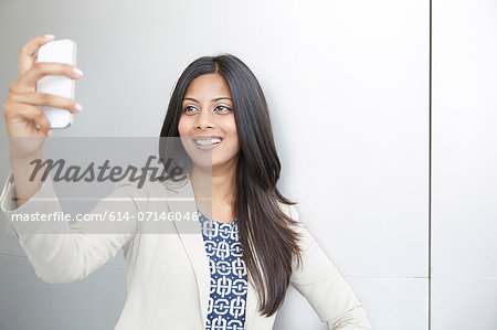 Woman taking self portrait using smartphone