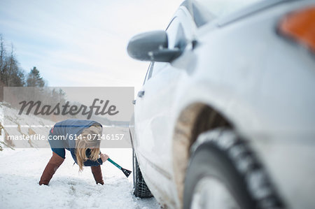 Woman digging car out from snow