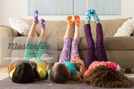 Three girls lying on floor with legs up