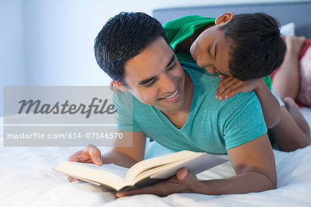 Father and son reading on bed