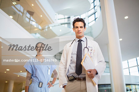 Portrait of confident doctor and nurse in hospital atrium
