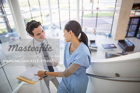 Doctor and nurse talking on staircase in hospital