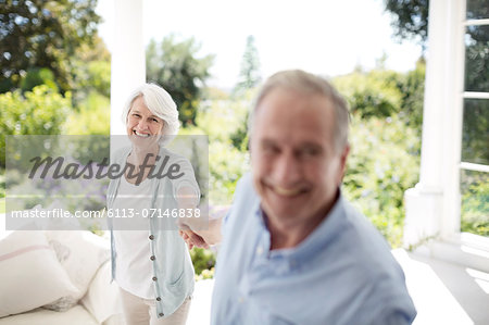 Senior couple holding hands on patio