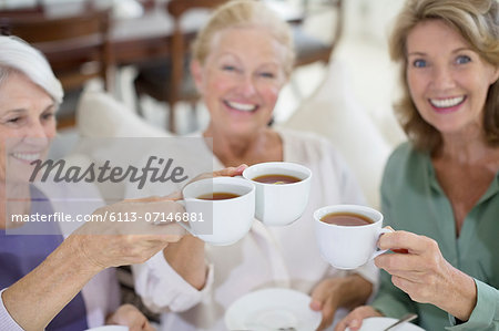 Senior women toasting coffee cups