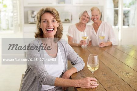 Portrait of smiling senior women drinking white wine