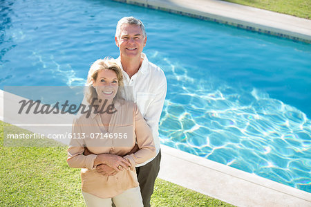 Portrait of smiling senior couple at poolside