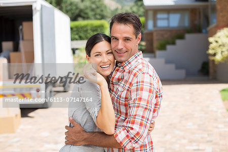 Portrait of smiling couple in front of new house