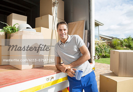 Portrait of man leaning on back of moving van