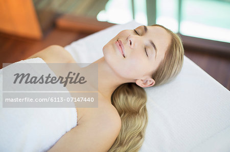 Smiling woman relaxing on massage table in spa