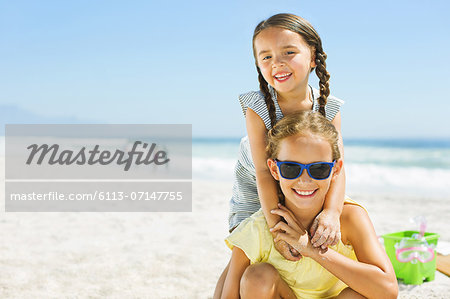 Portrait of smiling girls hugging on beach