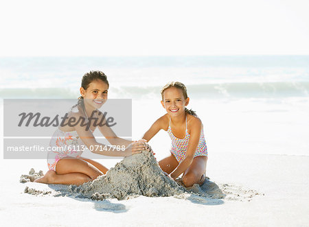 Girls making sandcastle on beach