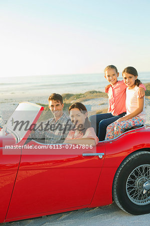 Family in convertible on beach