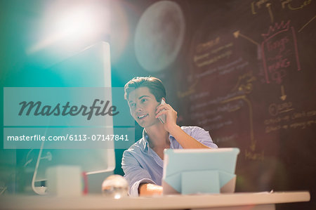 Businessman talking on telephone in office