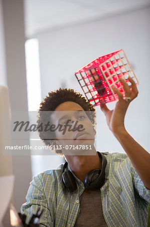 Businessman examining cube in office