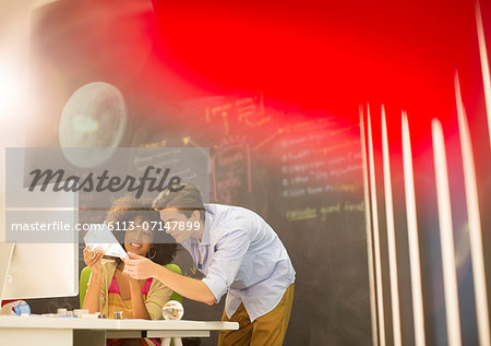 Business people examining model in office Business people examining model in office