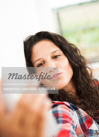 Teenage girl posing and taking selfie with smart phone, Germany