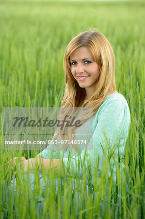 Blond young woman in a cornfield