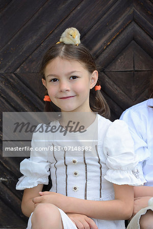 Girl with a chicken chick on her head