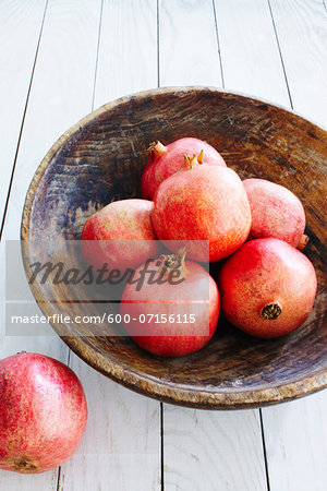 Pomegranats in wooden bowl, studio shot
