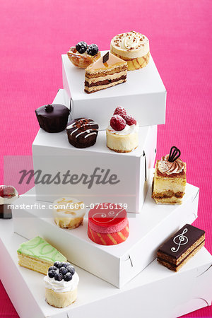 Variety of pastries and cakes on top of boxes, studio shot