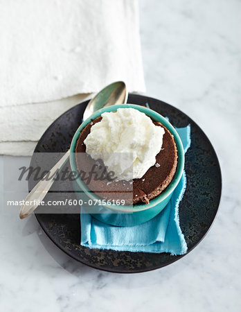 Dark Chocolate Souffles in ramekin on plate with sppon, studio shot