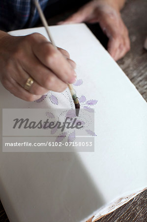 Close-up of person decorating stove tile