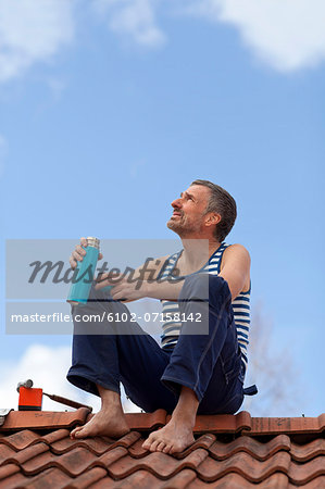 Mature man having coffee break on top of roof