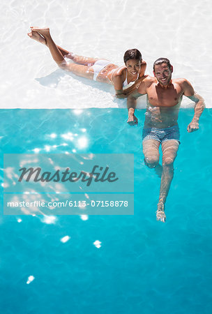 Portrait of smiling couple relaxing in swimming pool