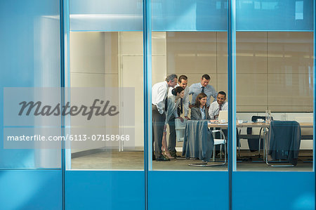 Business people using laptop in conference room