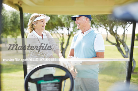 Senior couple laughing on golf course