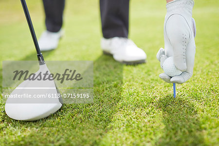 Man teeing golf ball on course