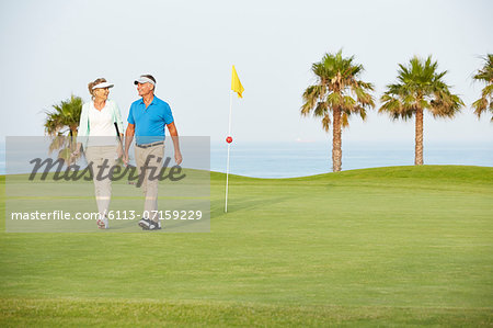 Senior couple walking on golf course