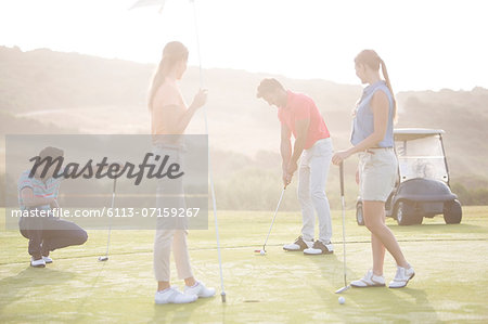 Friends playing golf on course