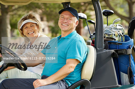 Senior couple smiling in golf cart