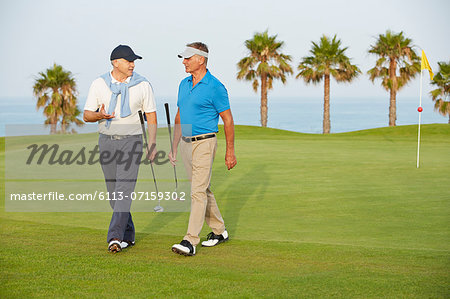 Senior men walking on golf course