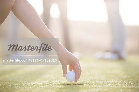 Woman teeing golf ball on course