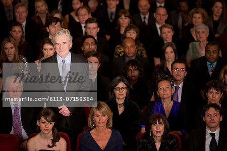 Serious man standing in theater audience