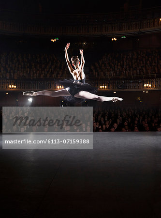 Ballerina mid-air on theater stage