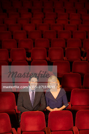 Portrait of smiling couple sitting in empty theater