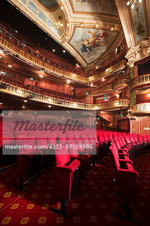 Balconies, seats and ornate ceiling in empty theater auditorium