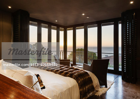 Luxury bedroom overlooking ocean at sunset