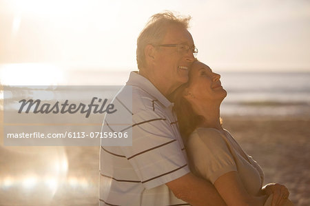 Older couple hugging on beach