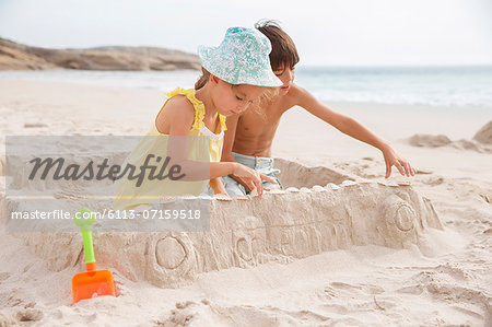 Children making sandcastle on beach