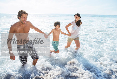 Family playing in waves at beach