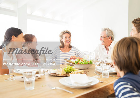 Multi-generation family eating together at table