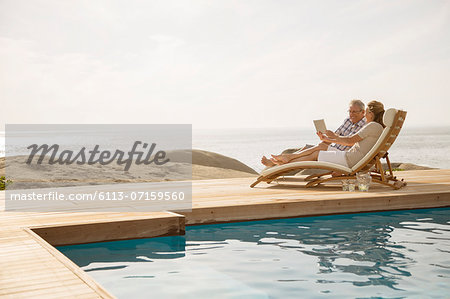 Older couple relaxing by pool