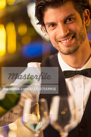 Close up portrait of well dressed bartender pouring wine