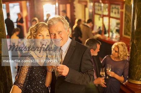 Portrait of well dressed couple toasting champagne flutes