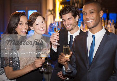 Portrait of well dressed couples toasting champagne flutes